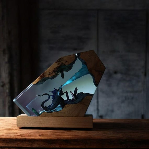 A hand-sculpted resin-and-wood diorama lamp where a monster lurks inside glowing epoxy — part night light, part miniature art installation.