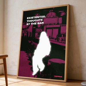 May include: A framed poster with the text "EXISTENTIAL THOUGHTS AT THE BAR" in white letters. The poster features a silhouette of a person sitting at a bar, with a dark background and purple accents. The poster is displayed in a room with a wooden chair and a floor lamp.