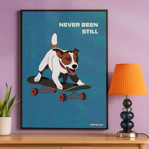 Illustrated poster of a small dog riding a skateboard on a blue textured background with the phrase “Never Been Still”, displayed hanging on a lillac wall next to an orange lamp and a small potted plant.