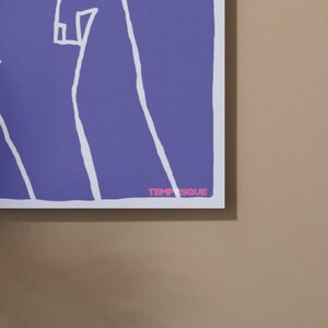 May include: A framed art print featuring a minimalist design with white lines on a purple background. The text "TEMPSQUE" is printed in pink at the bottom right corner. The artwork is displayed against a neutral-toned wall.