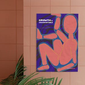 May include: A poster with the text "GROWTH IS UNCOMFORTABLE" in white on a dark blue background. The poster features a stylized, abstract figure in shades of coral and blue with yellow outlines. The poster is hanging on a pink tiled wall.