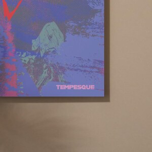 May include: Abstract art print with a textured appearance. The artwork features a blend of purple, blue, and red hues, with the word "TEMPESQUE" in white at the bottom. A red "V" shape is visible in the upper left corner.