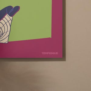 K&ouml;nnte beinhalten: Ein farbenfroher Kunstdruck mit einem gr&uuml;nen und magentafarbenen Hintergrund. Das Kunstwerk zeigt eine Hand mit blauen und wei&szlig;en Details. Das Wort "TEMPESQUE" ist unten im magentafarbenen Bereich wei&szlig; gedruckt.