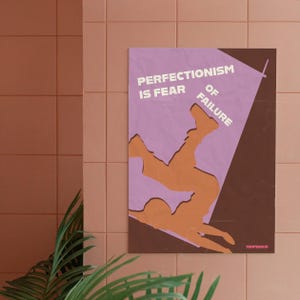 Può includere: Un poster incorniciato con la scritta "PERFECTIONISM IS FEAR OF FAILURE" in bianco. Il poster presenta una figura arancione che cade su uno sfondo viola e marrone. Il poster è appeso a una parete piastrellata rosa.
