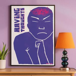 Minimalist purple illustration poster showing a stylized human figure with a tense expression and chaotic scribbles on the head, symbolizing overthinking and mental noise, with the text “Having Thoughts”. Displayed hanging on a lillac wall next to a small orange lamp and a potted plant.