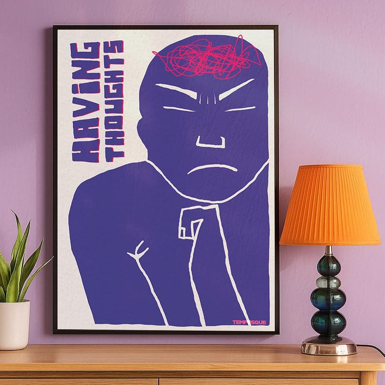 Minimalist purple illustration poster showing a stylized human figure with a tense expression and chaotic scribbles on the head, symbolizing overthinking and mental noise, with the text “Having Thoughts”. Displayed hanging on a lillac wall next to a small orange lamp and a potted plant.