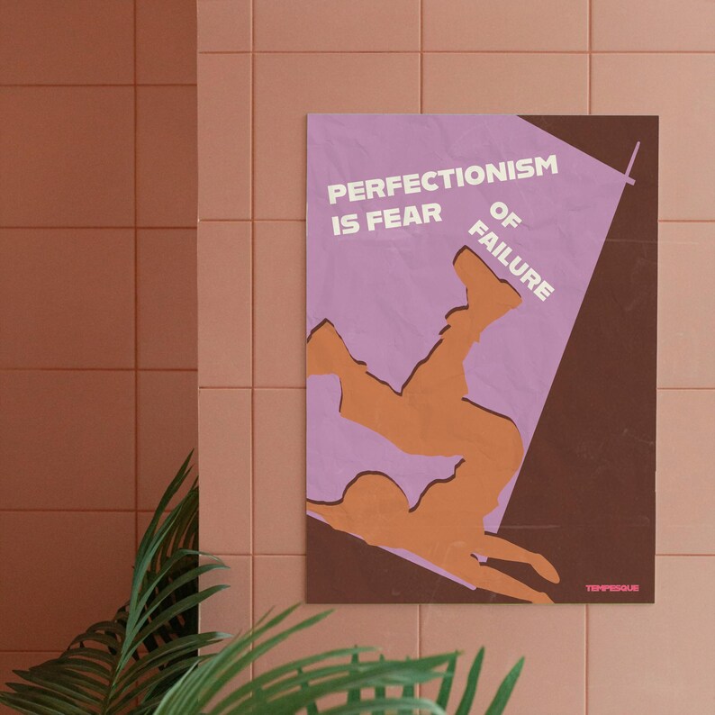 K&ouml;nnte beinhalten: Ein gerahmtes Poster mit dem Text "PERFECTIONISM IS FEAR OF FAILURE" in Wei&szlig;. Das Poster zeigt eine orangefarbene Figur, die vor einem lila und braunen Hintergrund st&uuml;rzt. Das Poster h&auml;ngt an einer rosa gefliesten Wand.