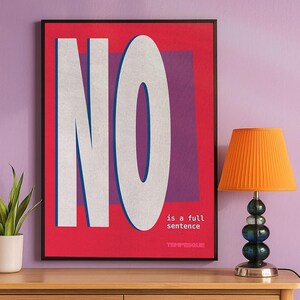 Bold typographic poster in red, purple, and white featuring the large word ‘NO’ and the phrase ‘is a full sentence’, displayed against a lillac wall next to a potted plant and an orange lamp.