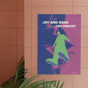 May include: Poster with the text "JOY AND RAGE CAN COEXIST" in white letters. A green silhouette of a person is walking on a blue and pink background. The poster is hanging on a peach-colored tiled wall.