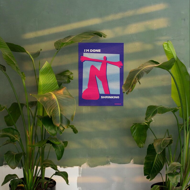 May include: A poster with the words "I'M DONE" and "SHRINKING" in white text. The poster features a pink figure with outstretched arms against a blue and white background. The poster is mounted on a green wall, with green plants in the foreground.
