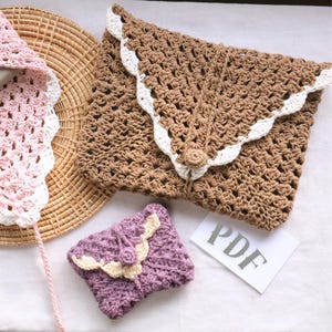 May include: A collection of handmade crochet items in various colors. The image features a large brown envelope-style clutch with white scalloped edges, a small purple wallet, and a pink and white bonnet. A paper with the text "PDF" is also visible.