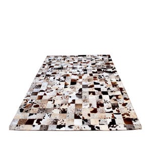 May include: A patchwork cowhide rug with a chequered pattern in shades of brown, white, and black.