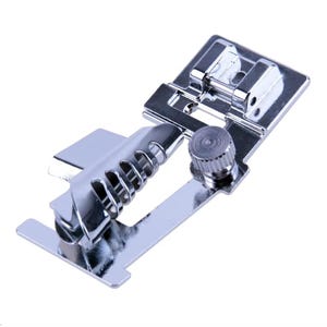 May include: A silver-coloured metal sewing machine presser foot attachment featuring a spiral hemmer guide with a slotted design and a small adjustable screw mechanism on the side for securing the component to the sewing machine shank.