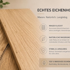 May include: Two rectangular light brown oak wood boards with visible grain patterns. The image includes German text: ECHTES EICHENHOLZ, Massiv. Naturlich. Langlebig, MASSIV & ECHT, NATURLICHE MASERUNG, STABIL & LANGLEBIG, and 100% MASSIVES EICHENHOLZ.