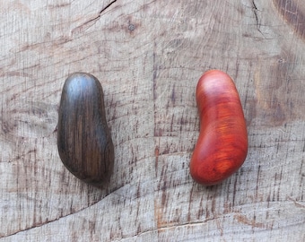 May include: Two wooden heart-shaped objects, one dark brown and one red with a wood grain pattern.