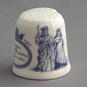 May include: White ceramic thimble with a blue and white design depicting King Edward I and Queen Eleanor of Castile. The thimble features the text "Edward I and Eleanor of Castile Westminster Abbey 1307".
