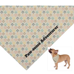 May include: A beige bandana with a geometric pattern of colorful squares and the text "Paw-some Adventurer" printed on it. A French Bulldog is wearing the bandana.