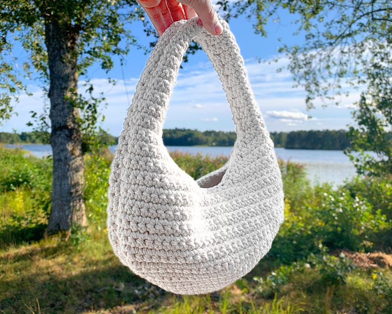 Modern virkad axelväska med snygg rund design.