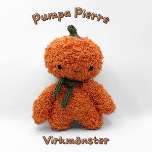 May include: An orange plush toy shaped like a pumpkin with a green scarf and stem. The toy has a friendly face with black eyes. Text above reads "Pumpa Pierre" and below reads "Virkmonster".