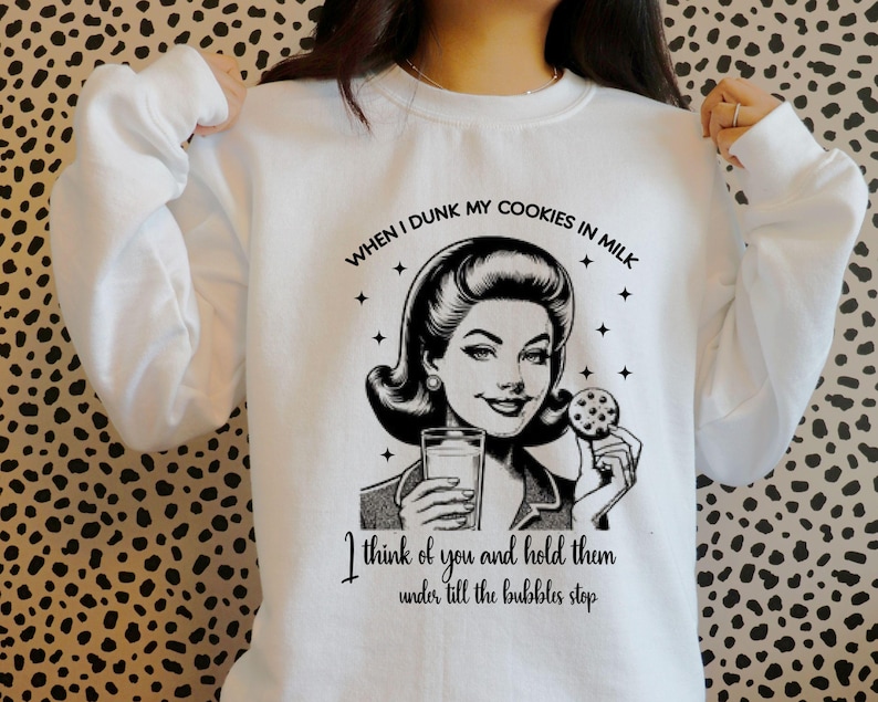 May include: White sweatshirt with a black and white illustration of a woman dipping a cookie in milk. The text reads "WHEN I DUNK MY COOKIES IN MILK I think of you and hold them under till the bubbles stop."