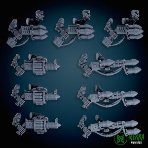 May include: A collection of gray miniature weapon models, including rocket launchers and other mechanical components. The models are detailed with various shapes and textures, suggesting a futuristic or sci-fi theme. The image is well-lit, showcasing the intricate designs.