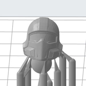 Puede incluir: Un casco gris futurista con visera y diseño angular. El casco tiene una estructura segmentada detallada con ventilaciones y una ceja prominente. Está soportado por varias estructuras verticales.
