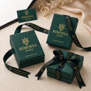 a collection of green jewelry boxes and a gift box with a ribbon, all bearing therimosa.jewelry branding.