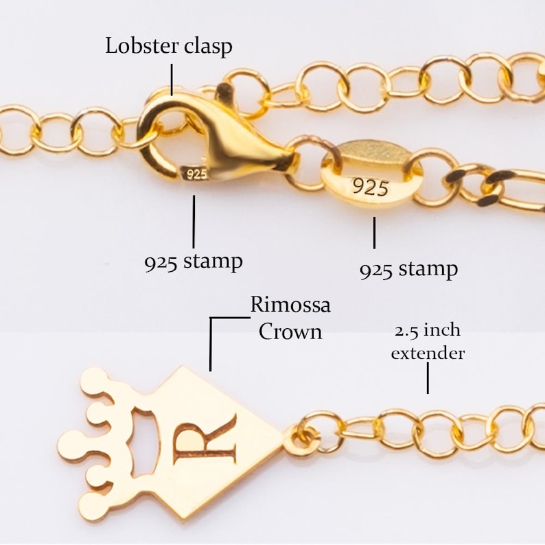 K&ouml;nnte beinhalten: Nahaufnahme einer goldfarbenen Halskette mit Karabinerverschluss und einem 6,35 cm Verl&auml;ngerungsst&uuml;ck. Die Halskette hat einen kronenf&ouml;rmigen Anh&auml;nger mit dem Buchstaben "R" und einem "925" Stempel. Die Kette besteht aus kleinen, verbundenen Gliedern.