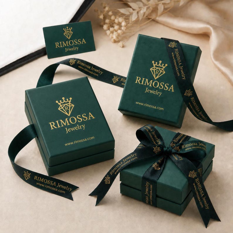 a collection of green jewelry boxes and a gift box with a ribbon, all bearing therimosa.jewelry branding.