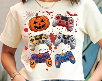 以下が含まれることがあります： ハロウィーンをテーマにしたデザインのクリーム色のTシャツ。グラフィックには、ジャック・オー・ランタン、包帯で包まれたゲームコントローラー、カボチャとクモの巣のデザインのコントローラーが含まれています。赤い血しぶきとクモの巣が不気味なテーマを完成させています。