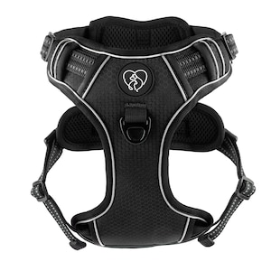 Puede incluir: Arnés para perro negro con un logotipo de corazón blanco y ribete plateado. El arnés tiene un diseño de malla y un anillo en D de metal.
