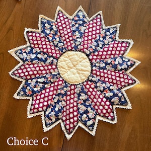 May include: A handmade, flower-shaped quilted trivet with a cream-colored center and alternating burgundy and navy blue petal sections. The petals feature floral and polka dot patterns, with a scalloped white lace edge. The text "Choice C" is at the bottom.