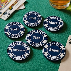 May include: A selection of navy blue and white poker chips, each bearing a different name such as "Scott" or "Mark". The chips are displayed on a green felt surface, alongside playing cards and a pint of beer.