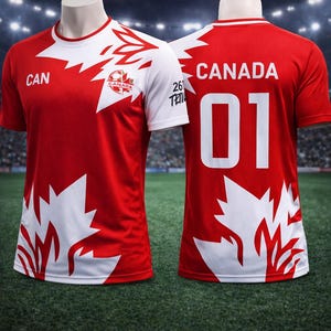 May include: Red and white soccer jersey with the word "CANADA" and the number "01" on the back. The front features the word "CAN" and a maple leaf design. The jersey has white sleeves and a white collar.