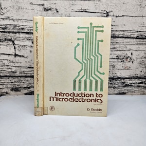 May include: A vintage textbook titled "Introduction to Microelectronics" by D. Roddy. The cover features a green circuit board design and the text "In SI/Metric Units." The book is a 2nd edition, published in Ontario, Canada.