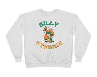May include: A light gray crewneck sweatshirt featuring a graphic print with the text BILLY STRINGS in green and yellow. The design includes two mushrooms in red and green, a small butterfly, and tiny flowers, all outlined in black ink.