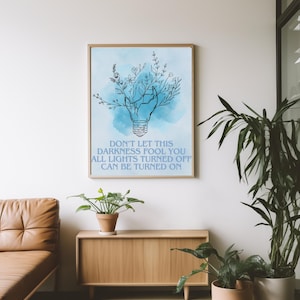 May include: A blue watercolor background with a black line drawing of a light bulb with flowers growing out of it. The text "Don't let this darkness fool you all lights turned off can be turned on" is below the image.