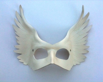 May include: White masquerade mask with large feathery wings on either side. The mask has two eye holes and is made of a smooth, lightweight material.