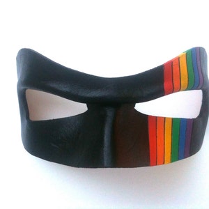 May include: A black leather mask with a rainbow stripe across the right eye.