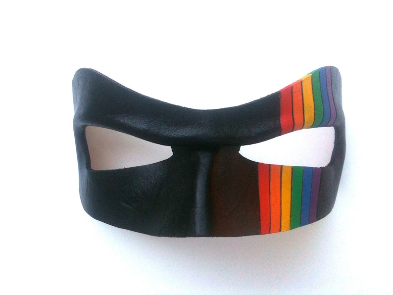 May include: A black leather mask with a rainbow stripe across the right eye.