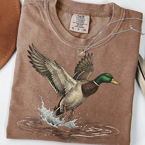 Ilustración de pato ánade real volando en formato PNG para sublimación. Ilustración naturalista vintage. Caza de patos. Salpicadura de agua. Descarga digital DTF para impresión.