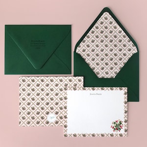 May include: Stationery set featuring a dark green envelope, a matching envelope with a floral patterned interior, and two notecards. One notecard has a floral border and the other has the name "Joanna Baker" printed on it.