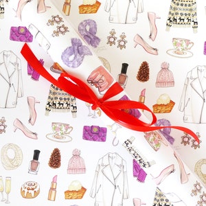May include: White wrapping paper with a repeating pattern of fashion illustrations, including a white jacket, pink heels, and a purple handbag. A red ribbon is tied around a rolled section of the paper.