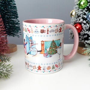 Può includere: Tazza in ceramica bianca con interno e manico rosa, con un design stravagante a tema Schiaccianoci. L'illustrazione include un topo, una ballerina, un albero di Natale e varie prelibatezze natalizie. La tazza è circondata da alberi di Natale in miniatura.