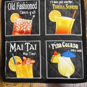 May include: Black quilted square featuring four cocktail illustrations: Old Fashioned, Tequila Sunrise, Mai Tai, and Piña Colada. Each image includes text with the cocktail name and additional phrases. The border is black.
