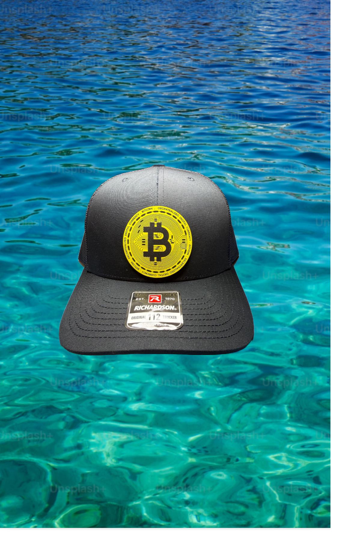 黒のリチャードソン 112 トラッカー ハットにビットコインの黄色いレザーレット パッチ。