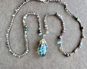 Blue swirling barnacle capped flamework pendant