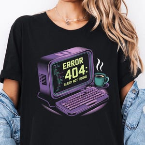 Pode incluir: Camiseta preta com um gráfico de computador retrô que diz "Erro 404: Sono não encontrado".