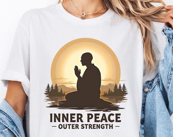 May include: White t-shirt with a graphic of a person meditating in front of a sunset with the text "Inner Peace - Outer Strength"