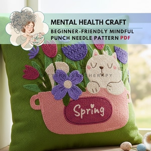 May include: Green pillow with a punch needle design featuring a pink flower pot with the word "Spring" and a white cat. The pot is filled with purple and pink flowers. Text at the top reads "MENTAL HEALTH CRAFT".